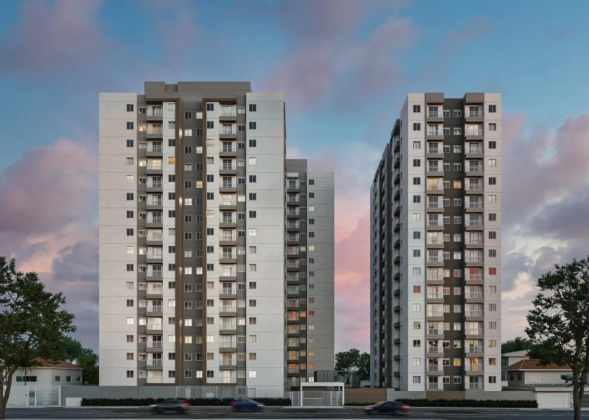 Fachada de torres residenciais com varandas e iluminação ao entardecer.