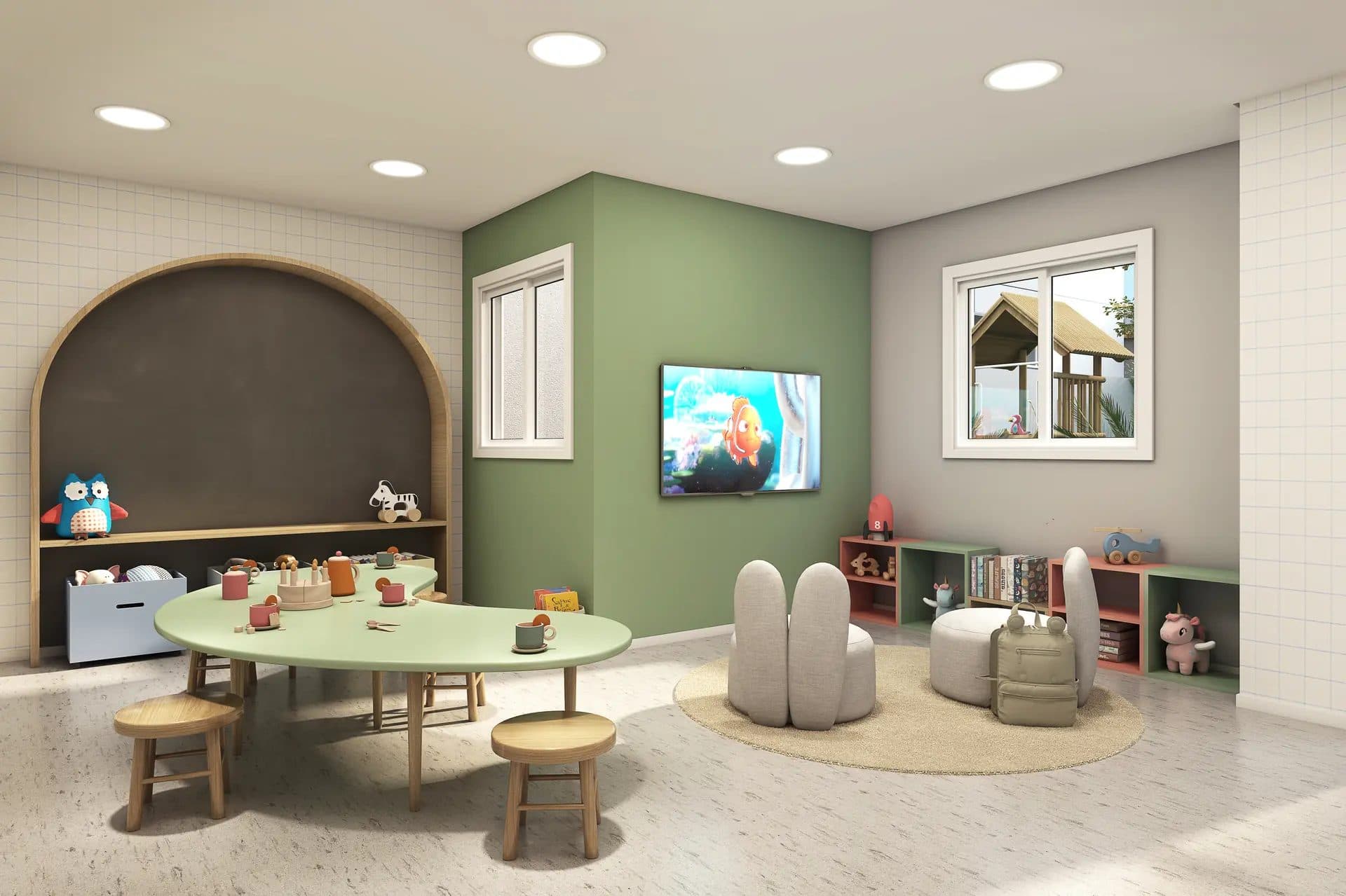 Brinquedoteca com mesa em formato orgânico, cadeiras infantis, TV na parede e nichos com brinquedos.